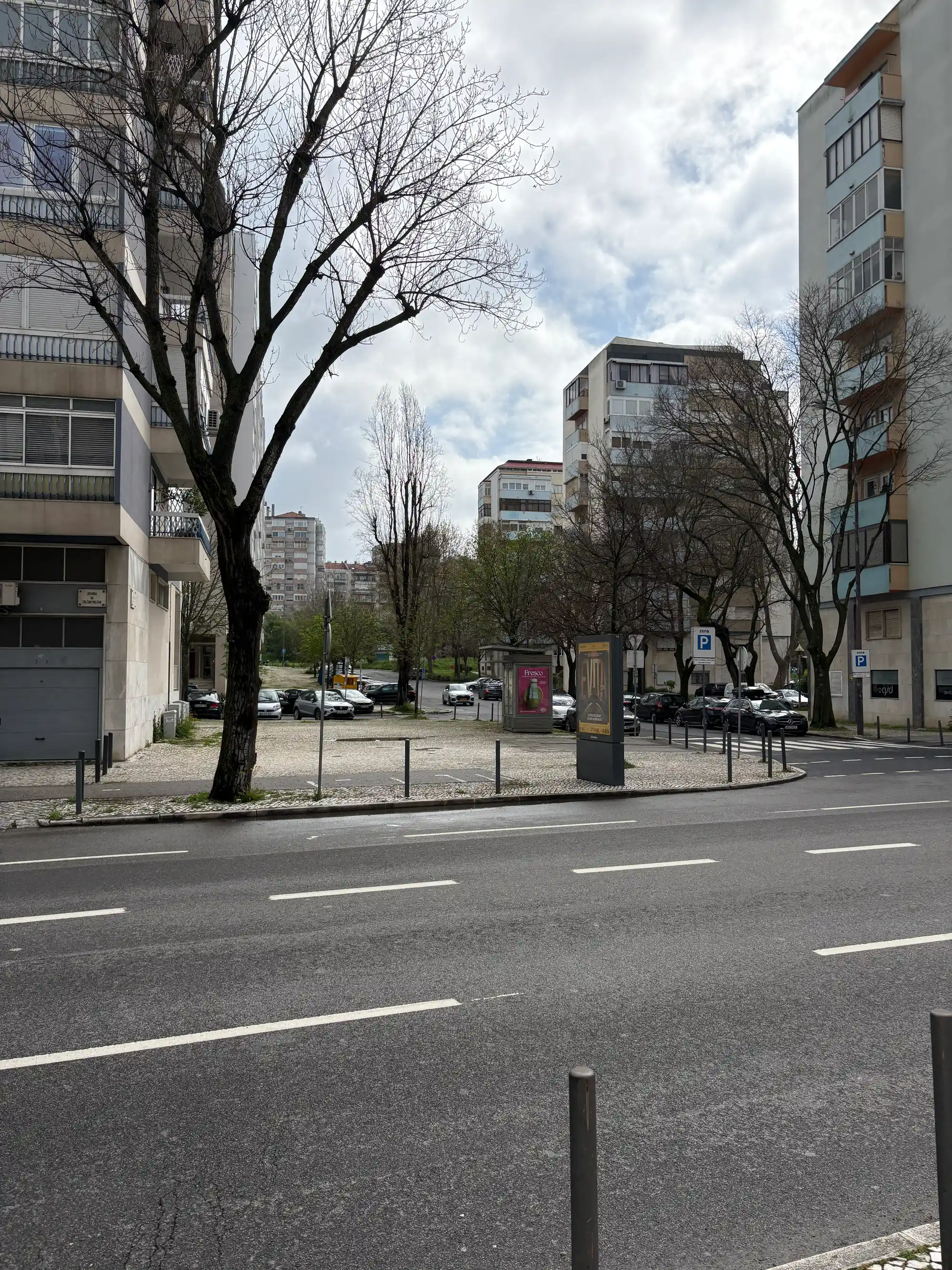 Benfica Lisbon residential street with apartment buildings, trees, parking area, and urban neighborhood environment