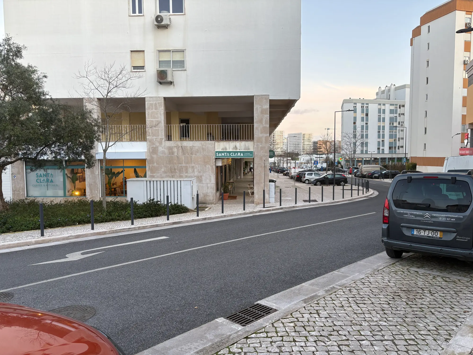 Santa Clara Lisbon residential street with modern buildings, local café, and parked cars in urban neighborhood